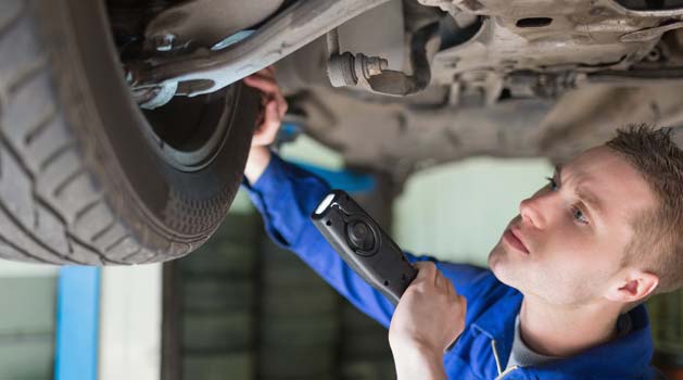 Mechanic inspecting car