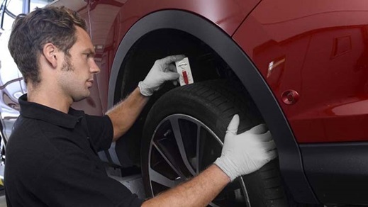 technician inspecting the tread on a tyre