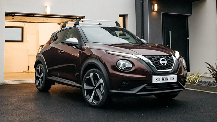 Purple Nissan Juke parked outside of house garage