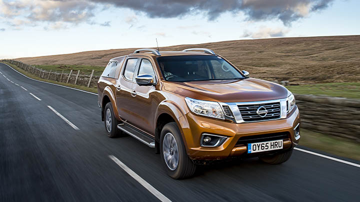 orange nissan navara, driving front quarter