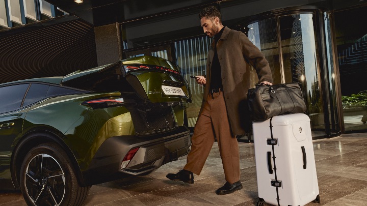 Green Peugeot 408 Exterior Rear with Person Loading Luggage