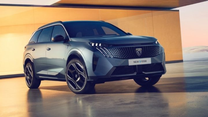 Petrol blue Peugeot 5008 parked in front of a orange wall