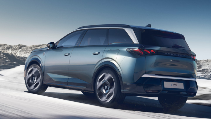 Peugeot E-5008 Dual Motor Finished in Ingaro Blue Driving on Snowy Road Rear Angle