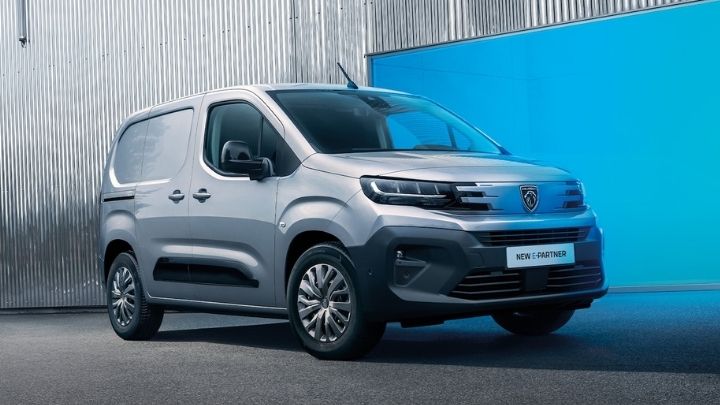 Front of a silver Peugeot e-Partner parked in front of a LED light panel lit up in blue
