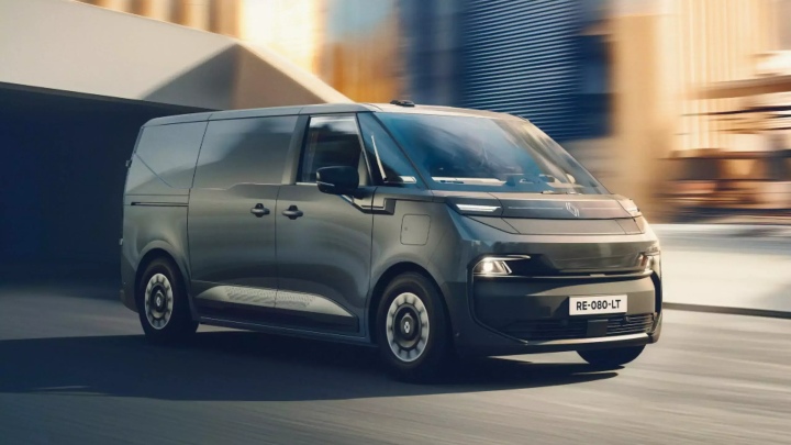 Renault Trafic Van E‑Tech electric van driving from a front three‑quarter angle in an urban setting