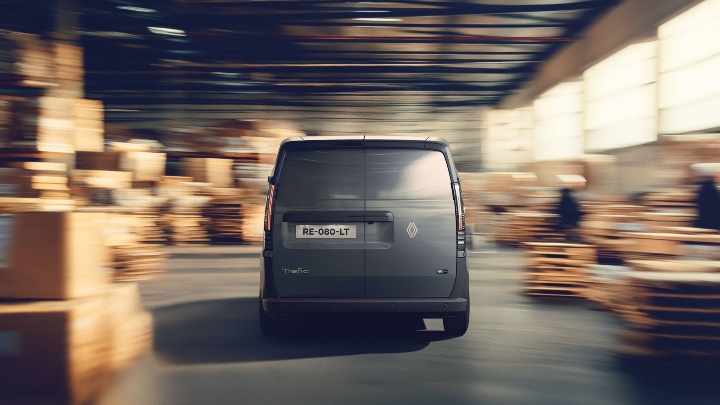 Rear view of the Renault Trafic Van E‑Tech electric van driving through a warehouse