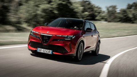 Red Alfa Romeo driving on the road