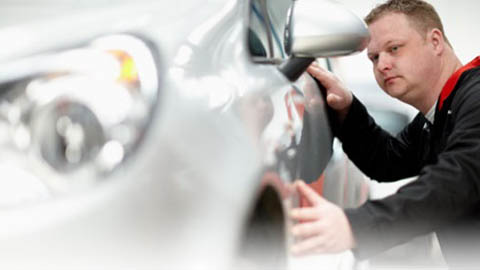 technician inspecting car body work