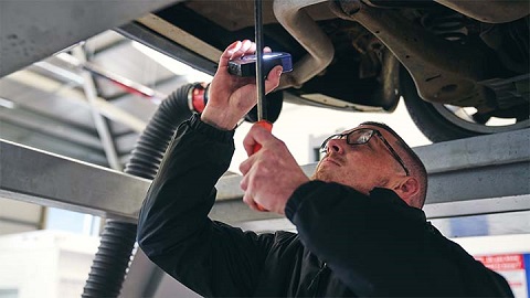 technician checking underside of vehicle during MOT