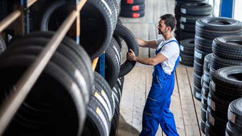 technician removing tyre from rack
