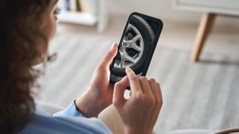 Someone checking their phone for a vehicle health check