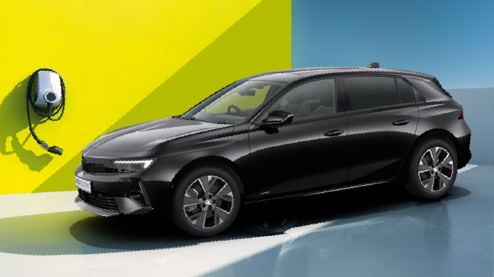 Black Vauxhall Astra being charged in front of a yellow wall