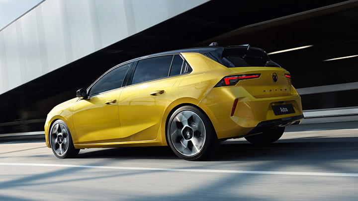 Yellow Vauxhall Astra Side Shot Driving