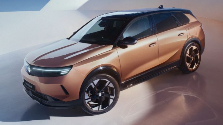 Front of Vauxhall Grandland facing the camera. The vehicle is being charged and the background is white and blue.