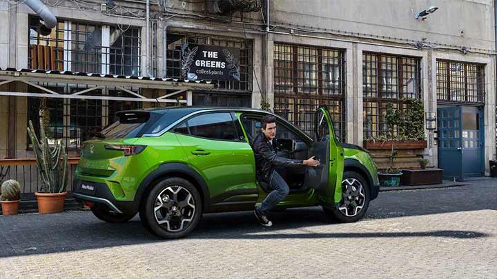 man climbing out of green vauxhall mokka x