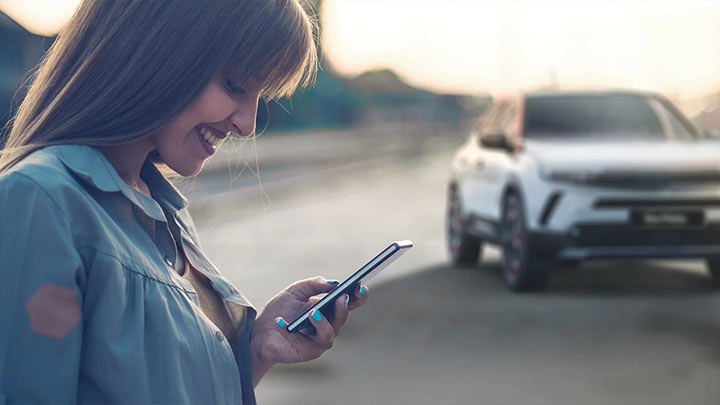 vauxhall mokka x owner playing on phone with mokka sat in the background