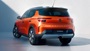 Back of an orange Vauxhall Frontera parked in a white background