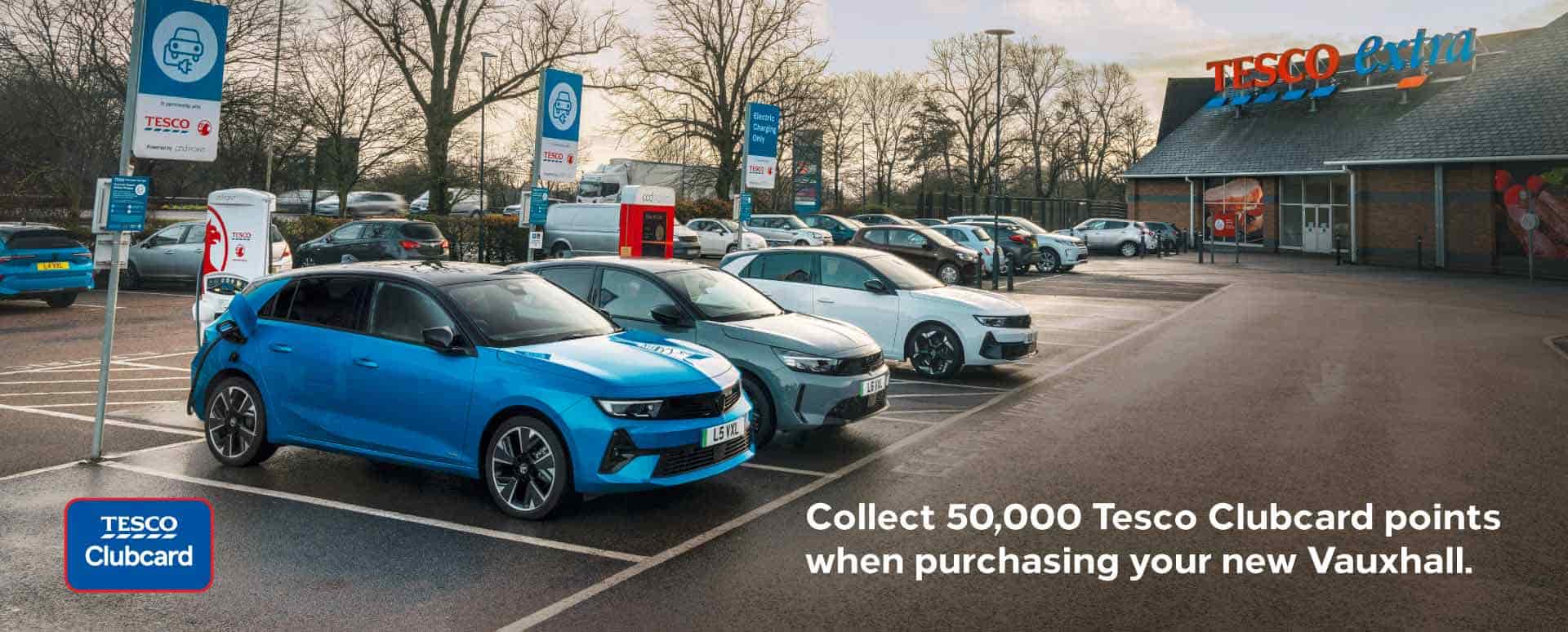 Tesco car park with several cars parked in most parking bays with the supermarket in the background