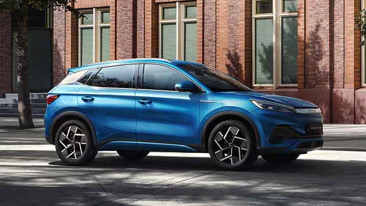 Blue BYD ATTO 3, driving down suburban street