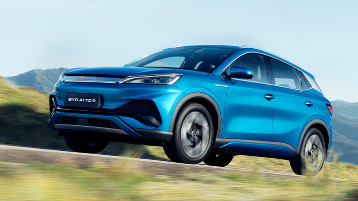 Blue BYD ATTO 3 driving through the mountains
