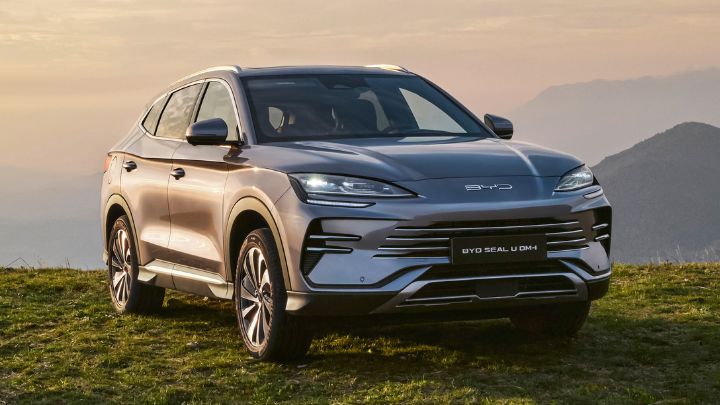 Silver BYD Seal U DM-i parked in the grass with mountains in the background