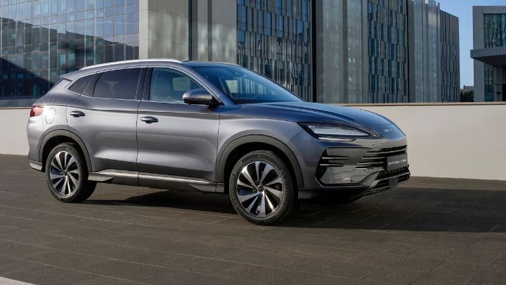 Silver BYD Seal U DM-i parked in front of several buildings in a large city