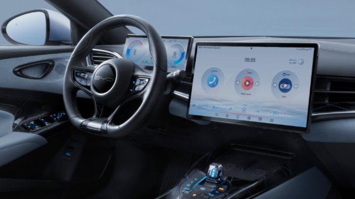 Inside BYD Seal with infotainment system on and steering wheel besides the screen